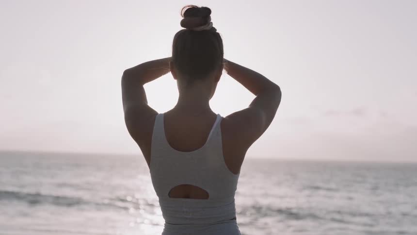 A woman does yoga on the beach