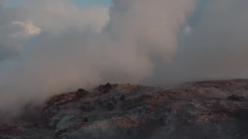 Smoke rolls over hills at sunset