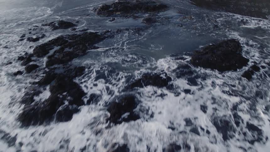 Rough seas are crashing into rocks sticking out of the ocean
