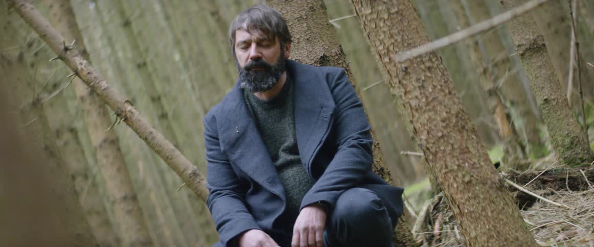 Man sits in a forest and closes his eyes