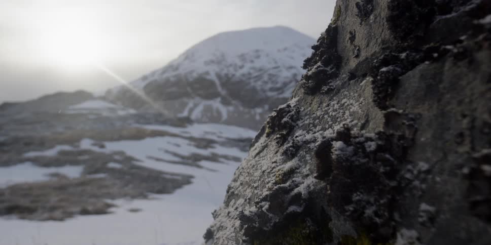 The sun shines on snow covered mountains