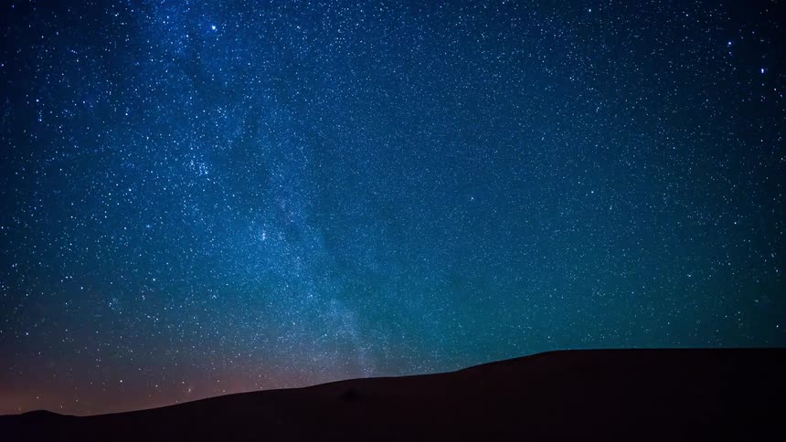 Stars move in a night sky over Sahara desert