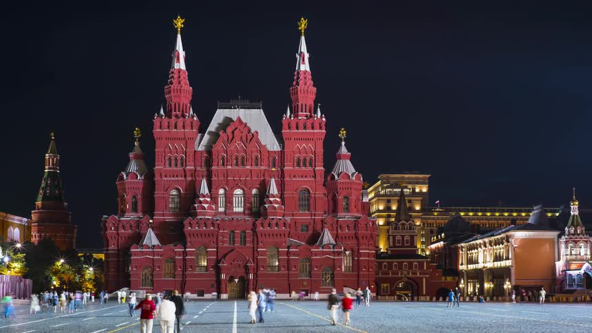 Tourists walk around the outside of Historical museum at Red Square in Moscow
