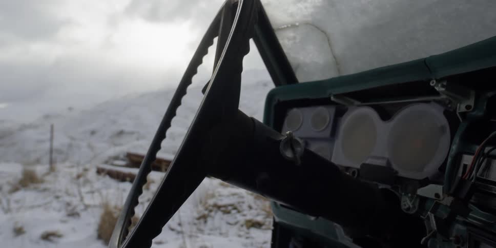 An abandoned truck sits in snowy mountains