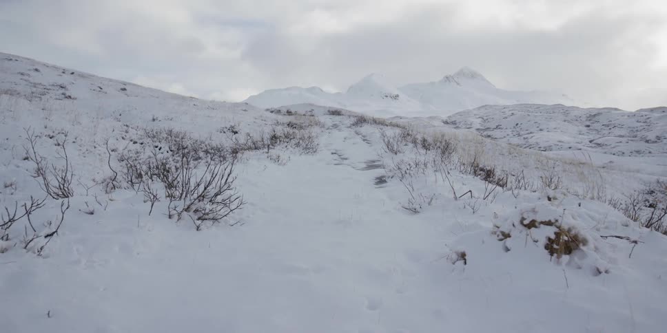 Snow covers the grounds by mountains