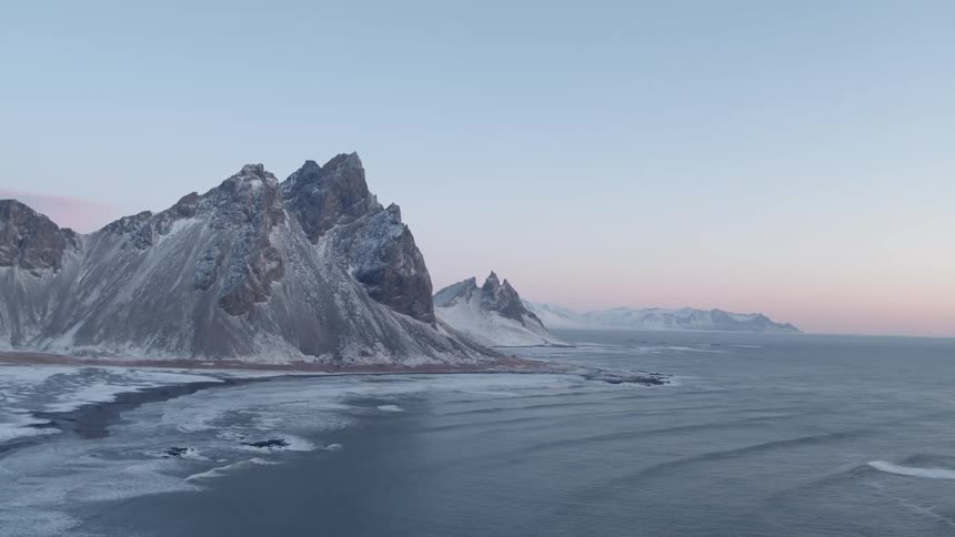 The waves crash against the icy rocks