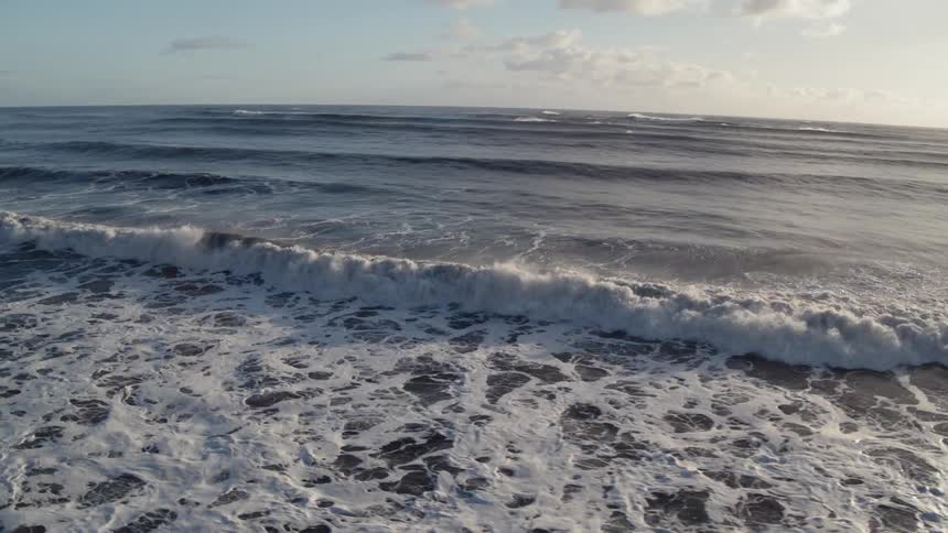 Waves flow onto the beach shore