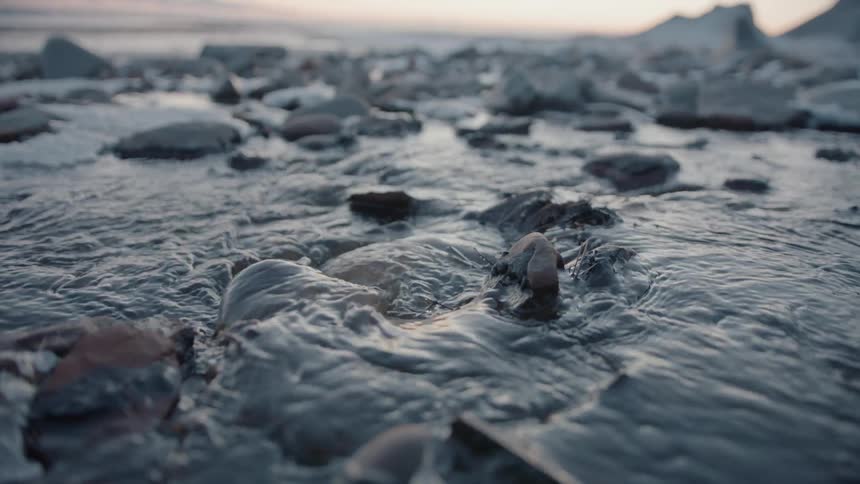 Water splashes and swirls around the rocks