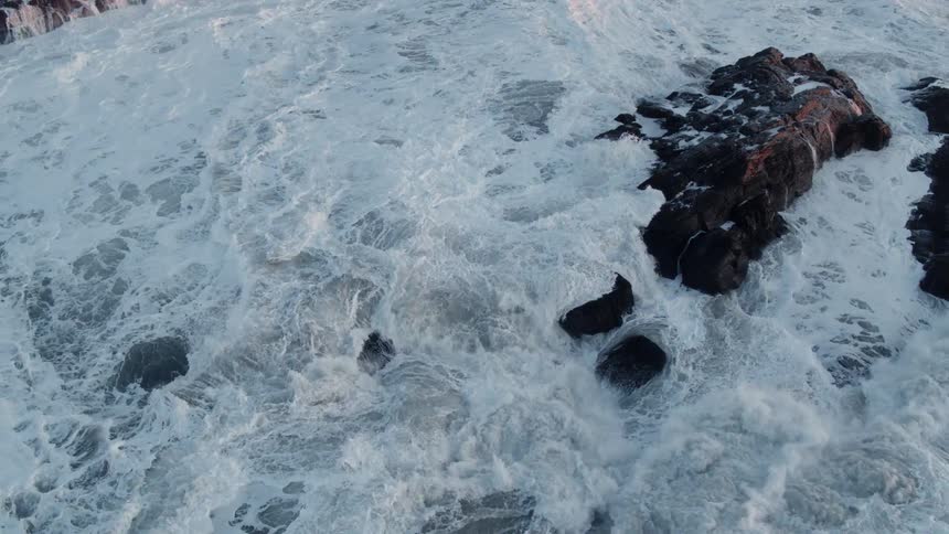 Waves crash onto the rock formations