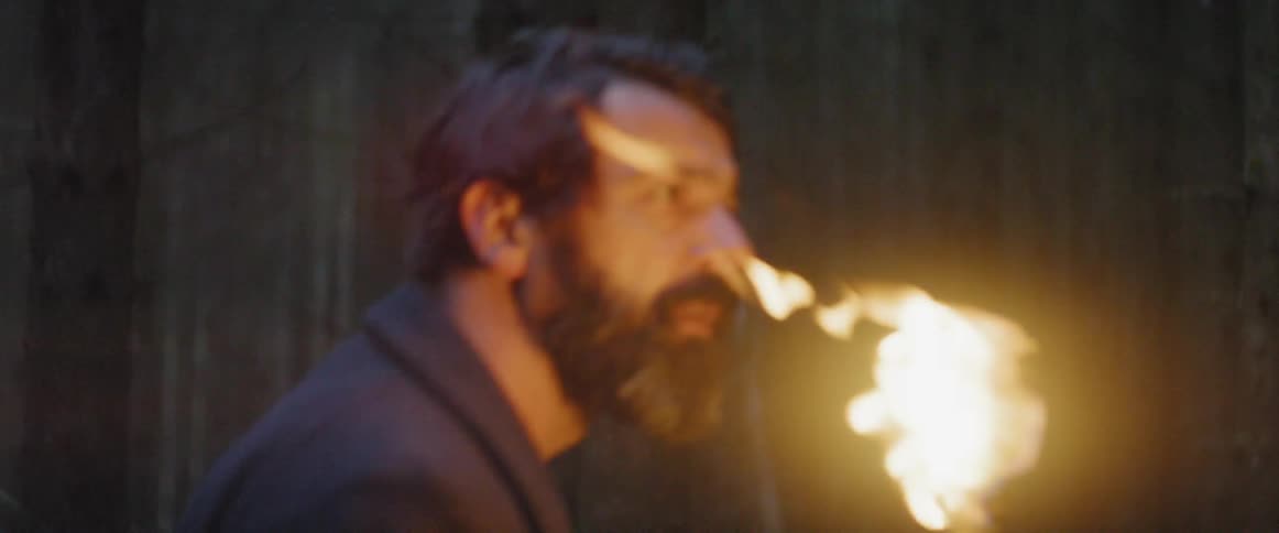A man carries a torch through the woods