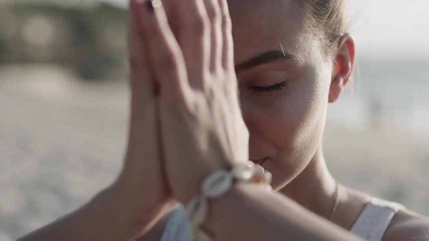 A woman puts her hands together in prayer