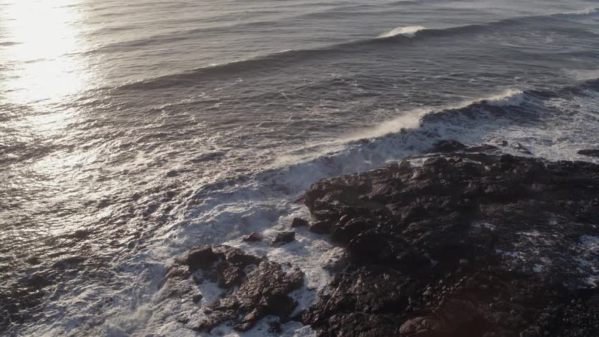 The waves slowly hit the rock shore