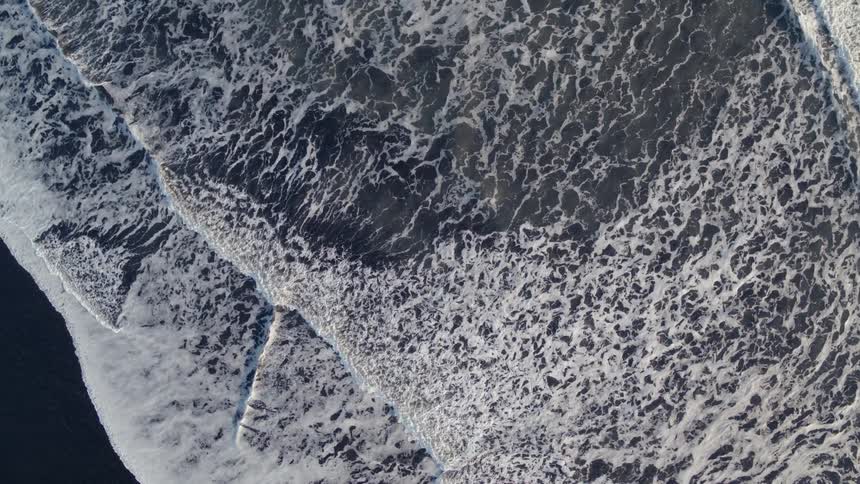 Ocean waves wash ashore a sandy beach