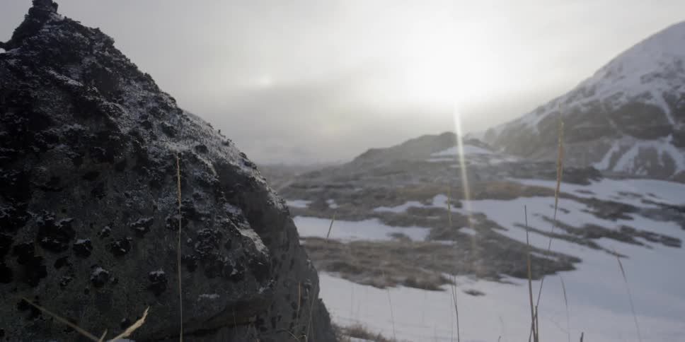 The sun shines on a snowy mountain