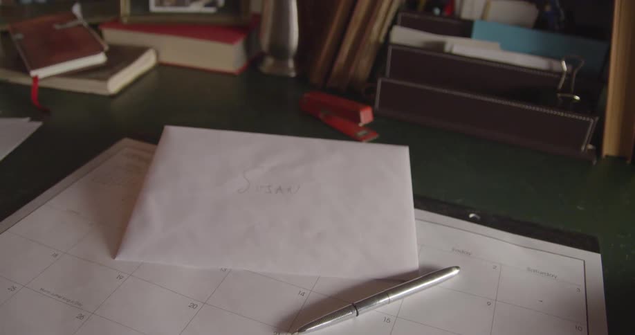 View of an envelope addressed to "susan" sitting on a calendar on a desk