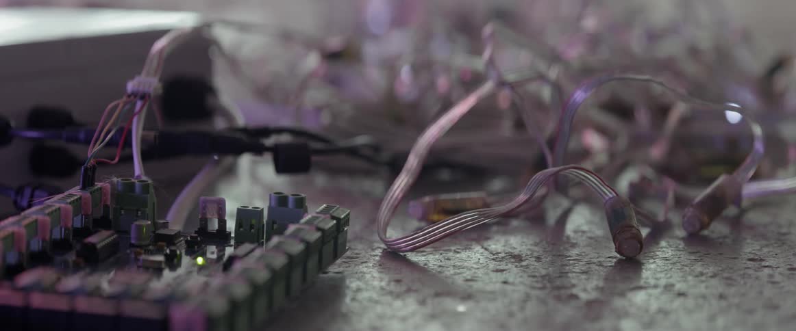 Lights flashing randomly on a string next to a circuit board on the floor