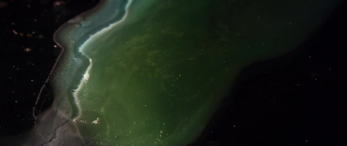 A thick green liquid is cascading down