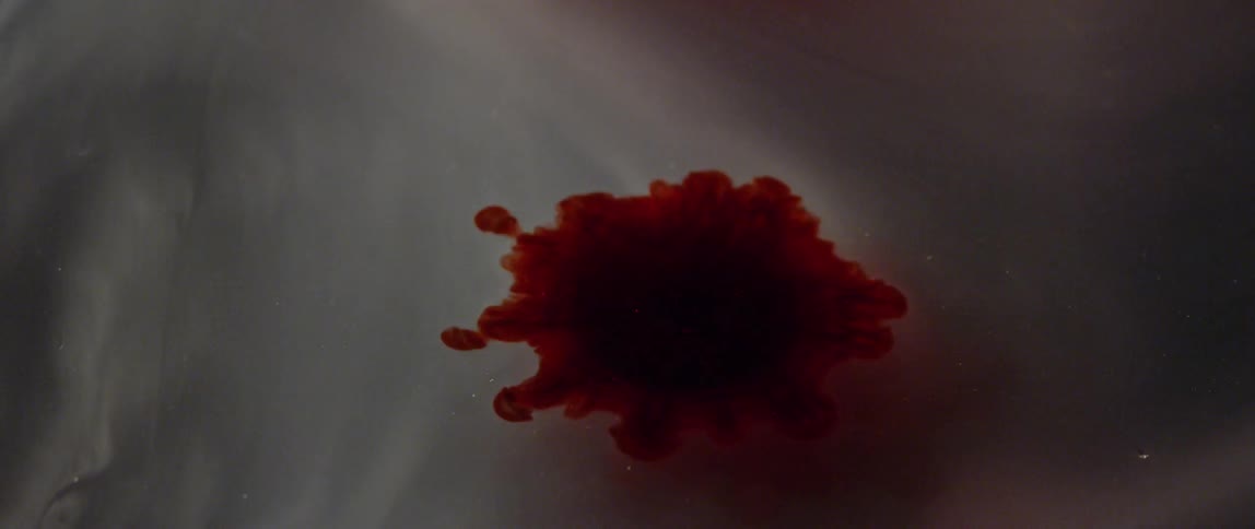 A red blob expands in liquid