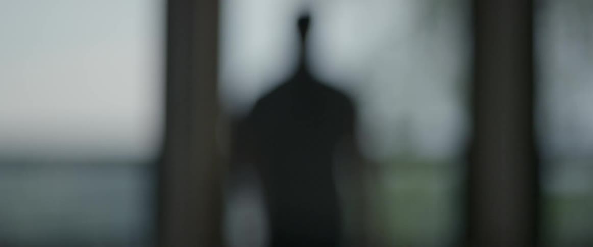 A man walks towards a window