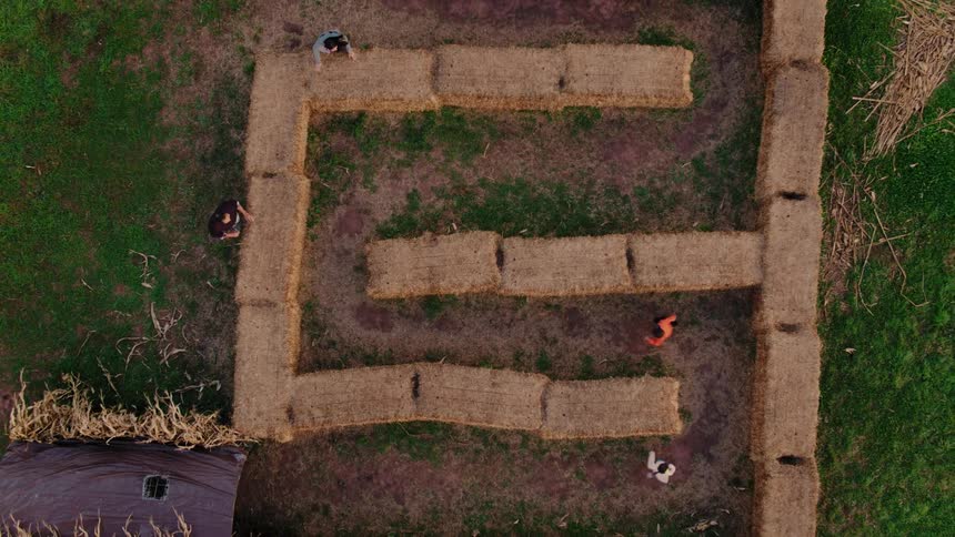Children playing in a hay maze