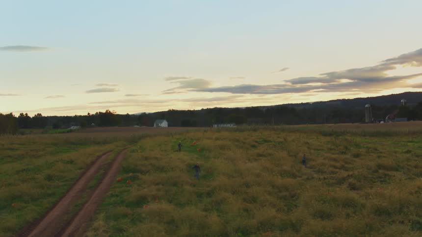 Some people are running across an open field in the country