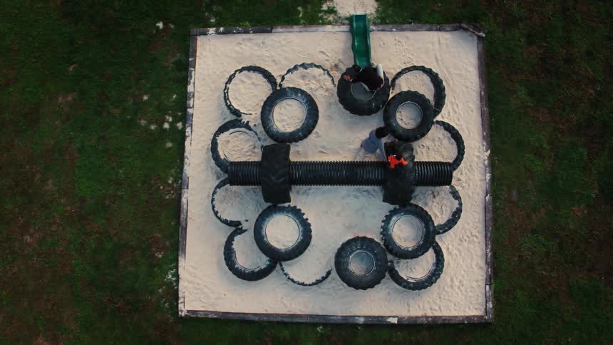 Kids play on large tires on a playground