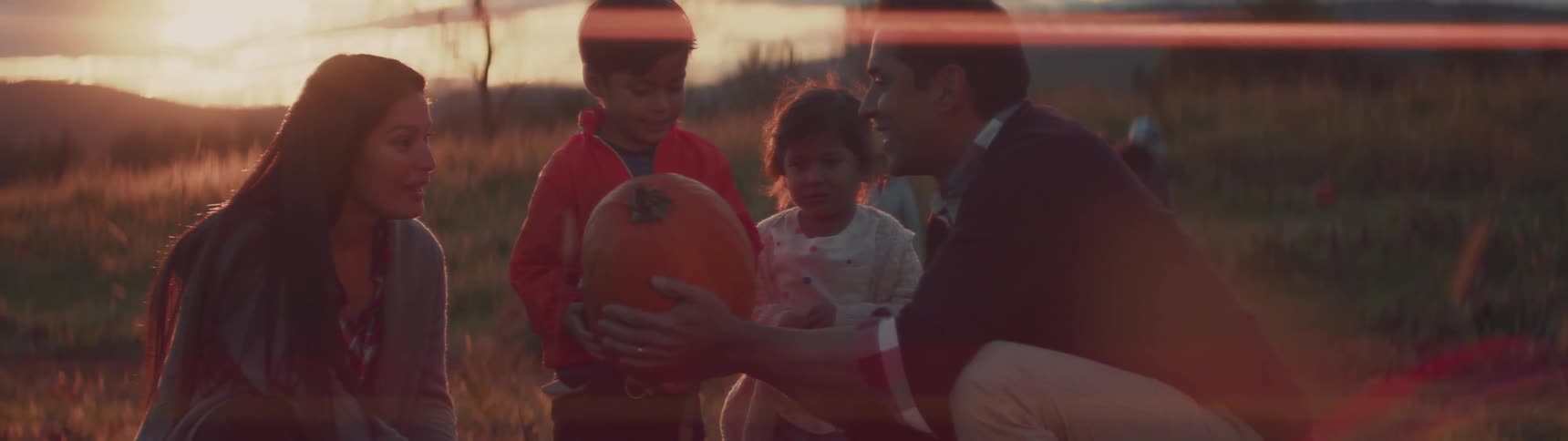 A family is picking a pumpkin together