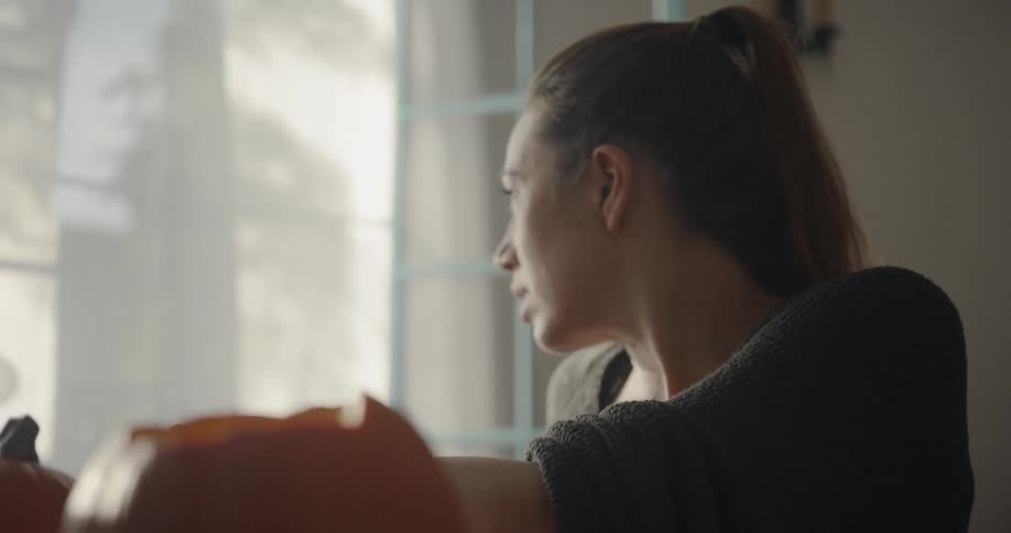 Woman carves pumpkins at home