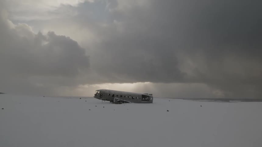 An old plane is setting in the middle of a frozen field
