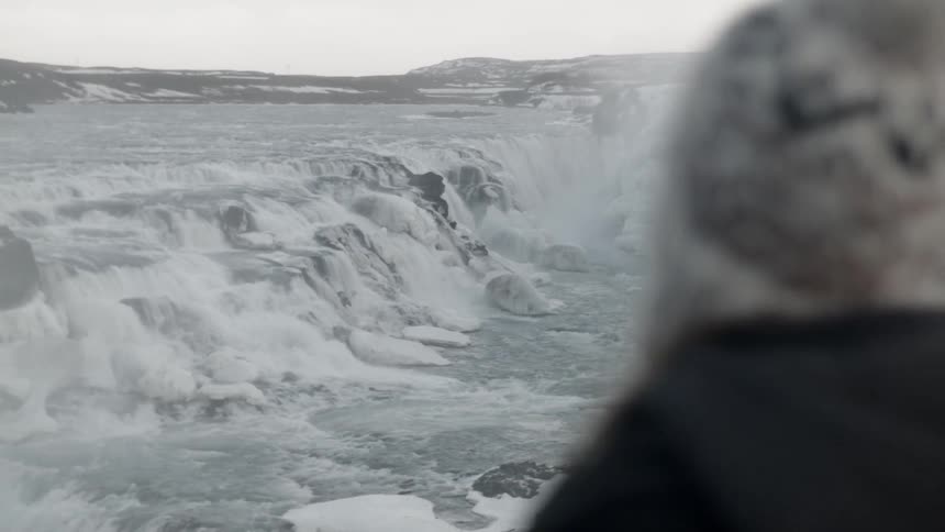 Someone is standing on a hill overlooking a frozen landscape and river