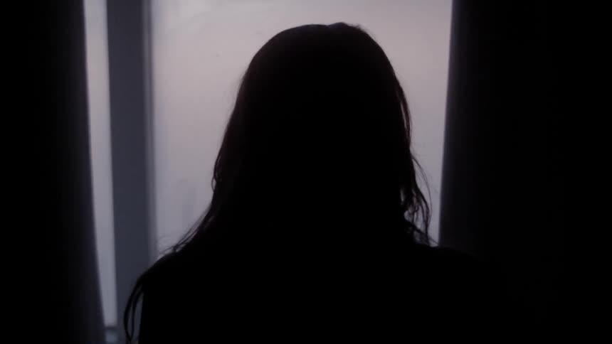 A woman is looking out of the door