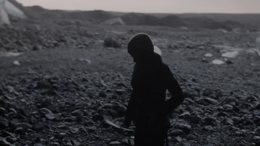 Woman stands in a rural field at sunset