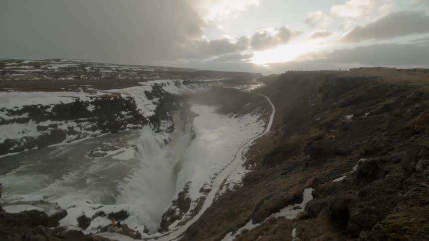 A frozen hillside drops down into a frozen lake
