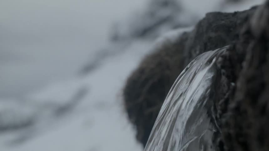 A very small water fall is falling between two rocks