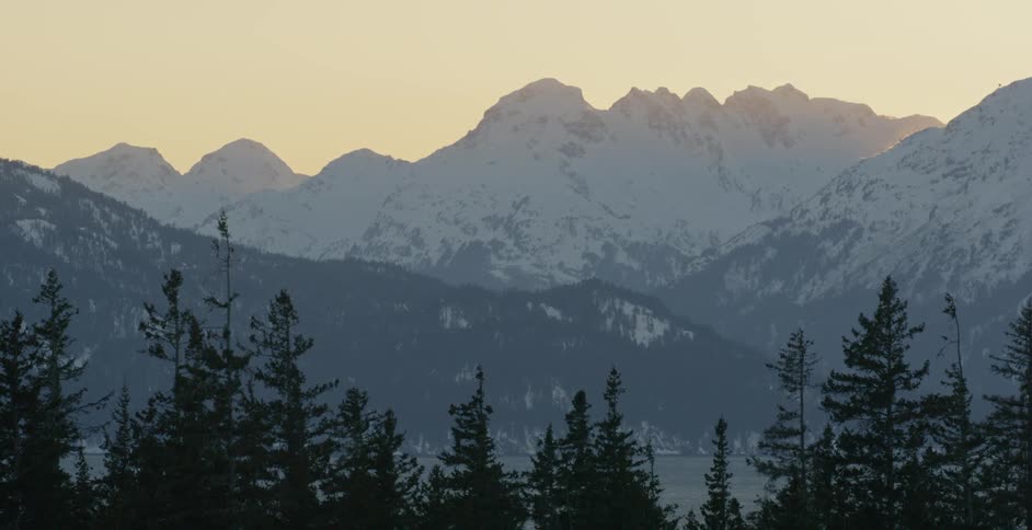 Snow is blanketing mountain peaks at dawn