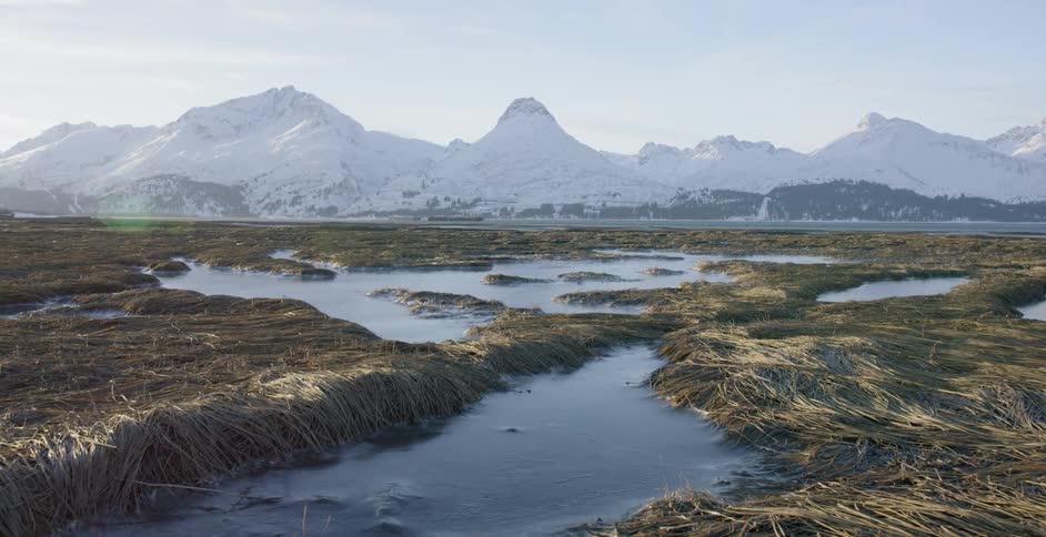 Water pools near the snow capped mountains