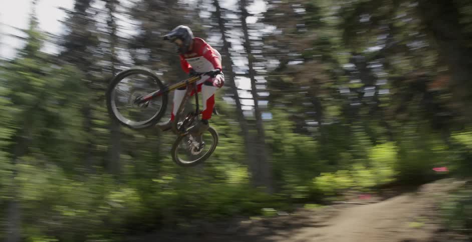 A person jumps on a hill using his mountain bike