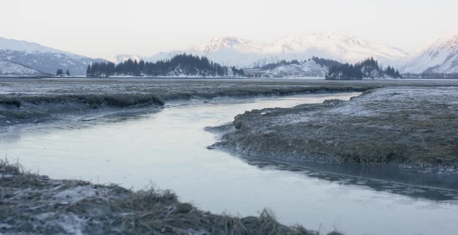 Ice is floating in a river flowing through a mountain valley during the day