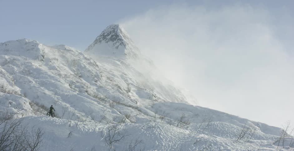 A man on a bike on a snowy mountain