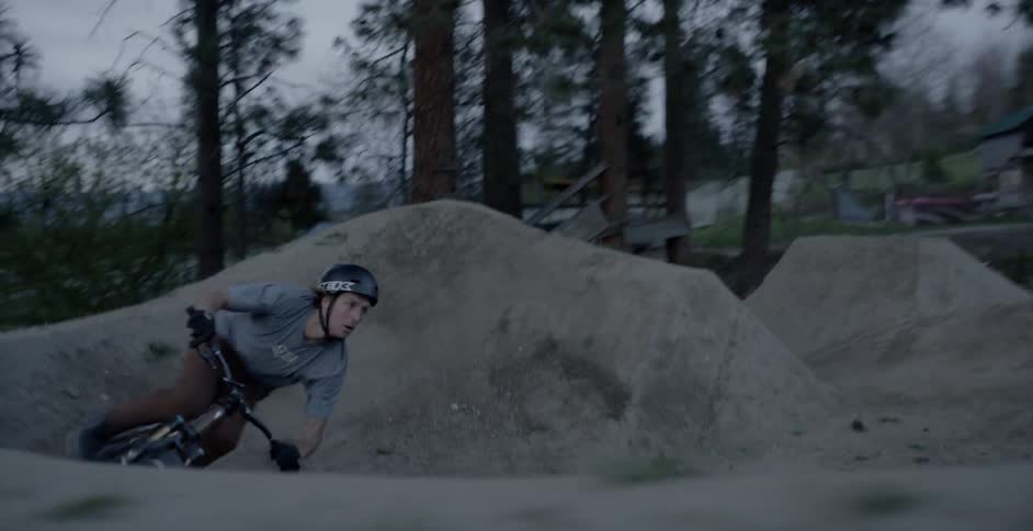 A bicyclist goes over a jump at sunset