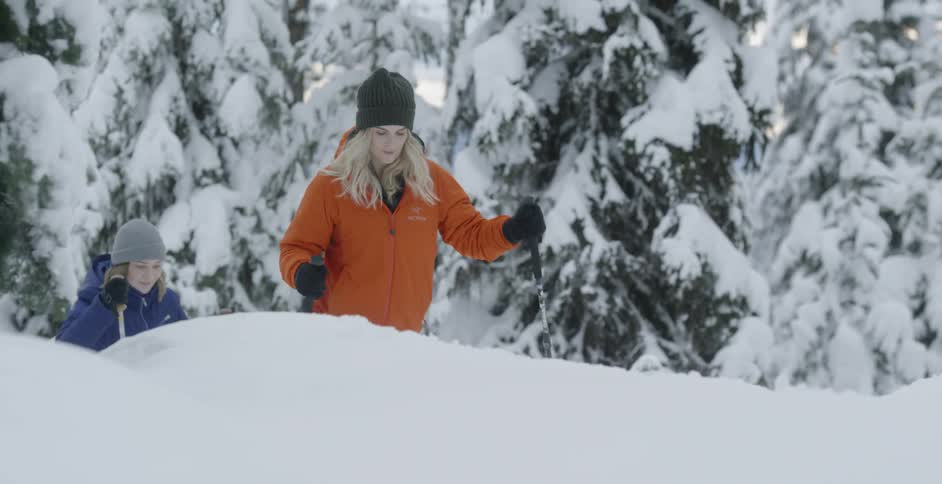 Women hike in snowy mountains
