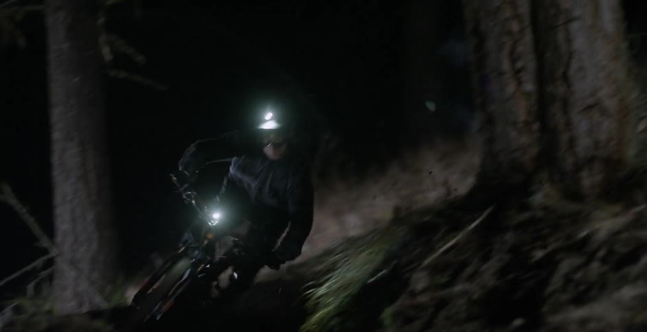 A person rides his mountain bike at night