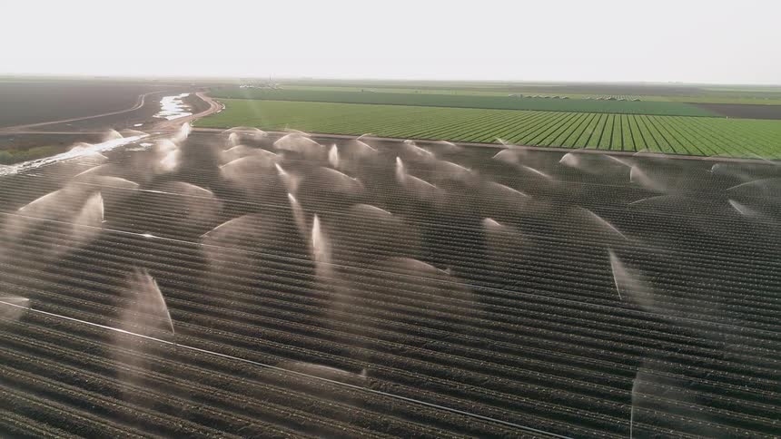 Sprinklers spraying over large fields of dirt