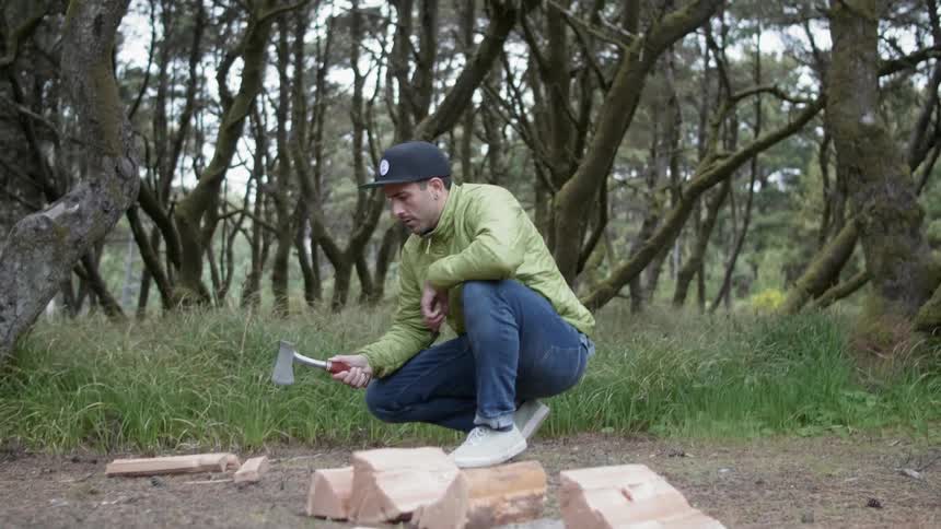 A man cuts firewood with an ax