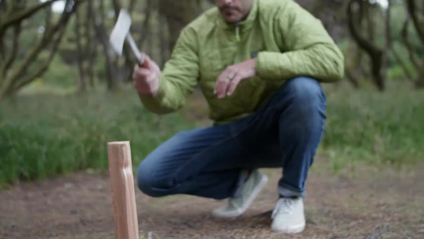 A man cuts firewood with an ax