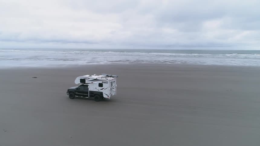 A recreational vehicle drives on the beach