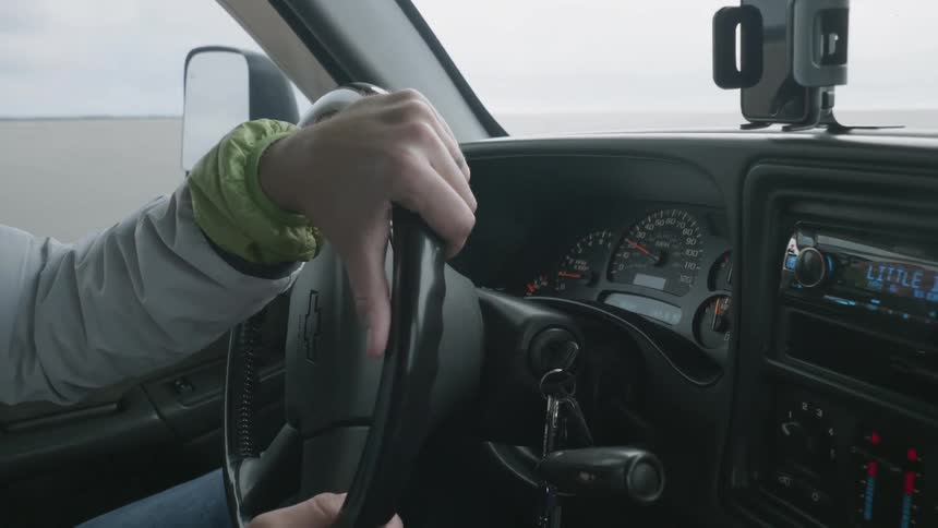A cell phone mounted on the dash wobbles as a person drives