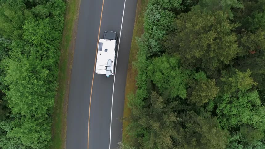 A recreational vehicle is traveling down the road