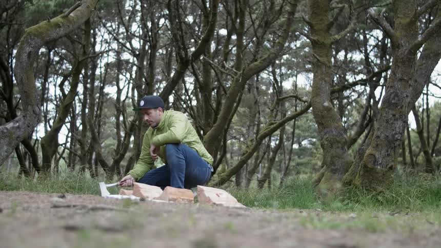 A man chops wood with a small hatchet