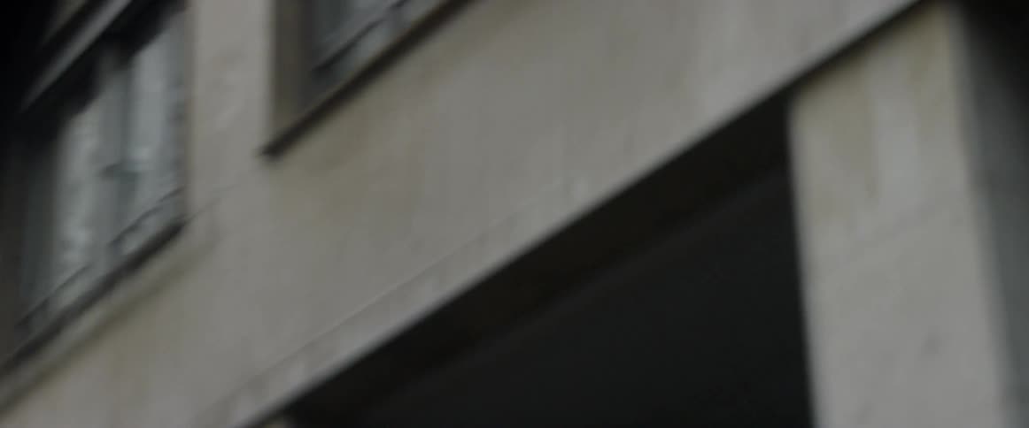 A vehicle drives by a city building